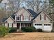 Charming two-story home featuring a two car garage, dark shutters and a well-maintained front yard at 54 Etham Pl, Douglasville, GA 30134