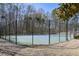Fenced in Community tennis court surrounded by mature trees on a sunny day at 54 Etham Pl, Douglasville, GA 30134