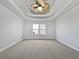 Main bedroom with tray ceiling, neutral carpet, and large window at 60 Legend Creek Holw, Douglasville, GA 30134