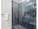 Modern shower with blue vertical tiles, a built-in niche, and a glass door at 727 Berkeley Nw Ave, Atlanta, GA 30318