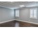 Basement area featuring wood floors, two windows with plantation shutters, and neutral wall paint at 3847 Admiral Dr, Chamblee, GA 30341