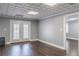 Basement area featuring French doors to the exterior, neutral paint, wood floors, and textured ceilings at 3847 Admiral Dr, Chamblee, GA 30341