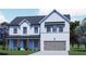 Two-story farmhouse style home with gray siding, brown accents, and a two-car garage at 3850 Ivy Cottage Se Dr, Snellville, GA 30039