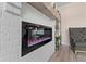 Modern electric fireplace with white brick surround and wooden mantel at 3850 Ivy Cottage Se Dr, Snellville, GA 30039
