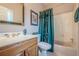Bathroom with a wood vanity, bathtub, and stylish green shower curtain at 5216 Old Mountain Ln, Powder Springs, GA 30127