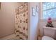 Bright bathroom featuring a floral shower curtain, white toilet, and decorative wall art at 5216 Old Mountain Ln, Powder Springs, GA 30127