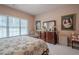 Bedroom featuring a decorative bedspread, window, dresser, and decorative wall art at 5216 Old Mountain Ln, Powder Springs, GA 30127