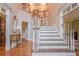 Two-story foyer featuring wood floors, staircase with decorative railings, and elegant decor at 5216 Old Mountain Ln, Powder Springs, GA 30127