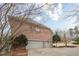 Three-car garage adjacent to the brick home featuring an expansive driveway, surrounded by mature landscaping at 5216 Old Mountain Ln, Powder Springs, GA 30127