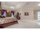 Large main bedroom suite featuring a tray ceiling, sitting area, and access to an ensuite bathroom at 5216 Old Mountain Ln, Powder Springs, GA 30127