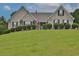 Brick house with a large front yard, lush landscaping, and a paved driveway at 1403 Shiloh Oak Dr, Loganville, GA 30052