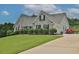 Brick house with a large front yard, lush landscaping, and a paved driveway with a red Smart car parked at 1403 Shiloh Oak Dr, Loganville, GA 30052