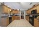 Kitchen with wood cabinets, black appliances, and granite countertops at 1403 Shiloh Oak Dr, Loganville, GA 30052