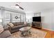 Living room boasts hardwood floors, gray sofas and large windows with natural light at 15 E Georgia Ave, Emerson, GA 30137