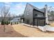 An exterior side view of a modern home with gray siding, chimney and manicured lawn at 56 Pine St, Roswell, GA 30075