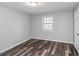 Bedroom with wood-look flooring, light gray walls, and natural lighting at 8690 Ashley Way, Douglasville, GA 30134