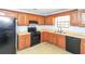 Functional kitchen featuring wooden cabinets, black appliances, and tile backsplash at 8690 Ashley Way, Douglasville, GA 30134