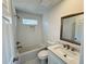 Cozy bathroom features tub-shower combo, updated vanity and tiling, and decorative window at 9240 Prestwick Club Dr, Duluth, GA 30097
