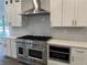 Gourmet kitchen featuring a professional range, stainless steel hood, and custom cabinetry at 9240 Prestwick Club Dr, Duluth, GA 30097