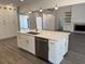 Kitchen island with stainless steel dishwasher, sink, quartz countertop, and custom cabinetry at 9240 Prestwick Club Dr, Duluth, GA 30097