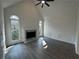 Vaulted living room showcasing a fireplace, arched windows, and modern ceiling fan at 9240 Prestwick Club Dr, Duluth, GA 30097
