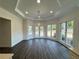 Bright sunroom with large windows, tray ceiling, modern light fixture, and wood-look floors at 9240 Prestwick Club Dr, Duluth, GA 30097