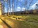 Landscaped backyard with mature trees and a stone wall at 4095 Maxanne Nw Dr, Kennesaw, GA 30144