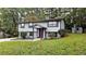 Gray sided house with red door and stone accents, on a grassy lot at 1906 Young Rd, Lithonia, GA 30058