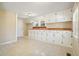 Spacious kitchen with white cabinets, butcher block countertops, and neutral tile flooring at 4293 Marietta St, Powder Springs, GA 30127