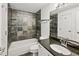 Well-lit bathroom featuring a granite countertop, a modern sink, and a tile-surround bathtub at 5200 Peachtree Rd # 3221, Chamblee, GA 30341