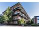 Modern brick apartment building with black metal balconies, surrounded by lush green landscaping and trees at 5200 Peachtree Rd # 3221, Chamblee, GA 30341