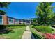 Walkway leads to the buildings, surrounded by lush green grass and manicured landscaping at 5200 Peachtree Rd # 3221, Chamblee, GA 30341