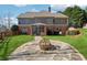 Spacious backyard featuring a stone patio with a fire pit and lush green lawn at 100 Pine Sandy Bank Dr, Canton, GA 30114