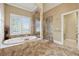 Bathroom with separate tub and shower, featuring light, neutral tile at 100 Pine Sandy Bank Dr, Canton, GA 30114