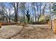 Expansive backyard with a wooden fence, mature trees, and space for gardening and outdoor activities at 530 Bolton Nw Rd, Atlanta, GA 30331