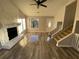 Open living area showcasing wood floors, stone fireplace, stairs, and large windows, creating a bright space at 1126 Mainstreet Valley Dr, Stone Mountain, GA 30088