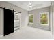 Bright bedroom with two windows, ceiling fan, and barn door to en-suite bathroom at 2329 Mason Dr # D24, Atlanta, GA 30316