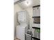 Stackable washer and dryer in a small laundry room with shelving at 849 Hillandale Ln, Lithonia, GA 30058