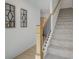 Carpeted staircase with a light wood handrail, decorative wall art, and wood flooring at 107 Winsome Way, Woodstock, GA 30188