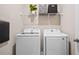 Well-lit laundry room features a modern side-by-side washer and dryer and shelving at 3335 Park Pointe Cir, Scottdale, GA 30079