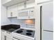 A well-lit kitchen features white appliances, cabinets and countertops, with black hardware at 1 Biscayne Nw Dr # 809, Atlanta, GA 30309