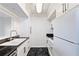 This galley kitchen features white cabinets, black marble floors and black countertops at 1 Biscayne Nw Dr # 809, Atlanta, GA 30309