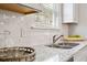 Bright kitchen with granite countertops, modern sink, tile backsplash, and stainless steel faucet at 120 Asher Dr, Carrollton, GA 30116