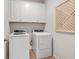 Laundry room with new white washer and dryer set, featuring convenient overhead cabinet storage at 120 Asher Dr, Carrollton, GA 30116