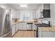 Well-lit kitchen with stainless steel appliances, granite countertops, and white cabinetry at 204 Natchez Trce, Sandy Springs, GA 30350