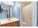 The bathroom has a wooden vanity, large mirror and a white shower curtain at 775 River Cliff Ct, Suwanee, GA 30024