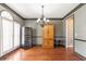 Traditional dining room featuring hardwood floors, elegant lighting fixture, and built-in wine storage at 775 River Cliff Ct, Suwanee, GA 30024