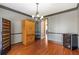 Dining room featuring hardwood flooring, a gray accent wall, dark trim, and decorative lighting at 775 River Cliff Ct, Suwanee, GA 30024