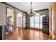 Dining room featuring hardwood flooring, a gray accent wall, dark trim, and decorative lighting at 775 River Cliff Ct, Suwanee, GA 30024