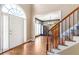 The foyer features hardwood floors, a staircase, and a view into the dining room at 775 River Cliff Ct, Suwanee, GA 30024